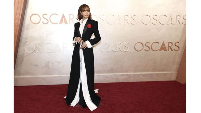 Lisa BLACKPINK tampil edgy dan berbeda dalam penampilan perdananya di karpet merah Piala Oscar 2025. Ia mengenakan setelan monokrom dengan tuksedo.