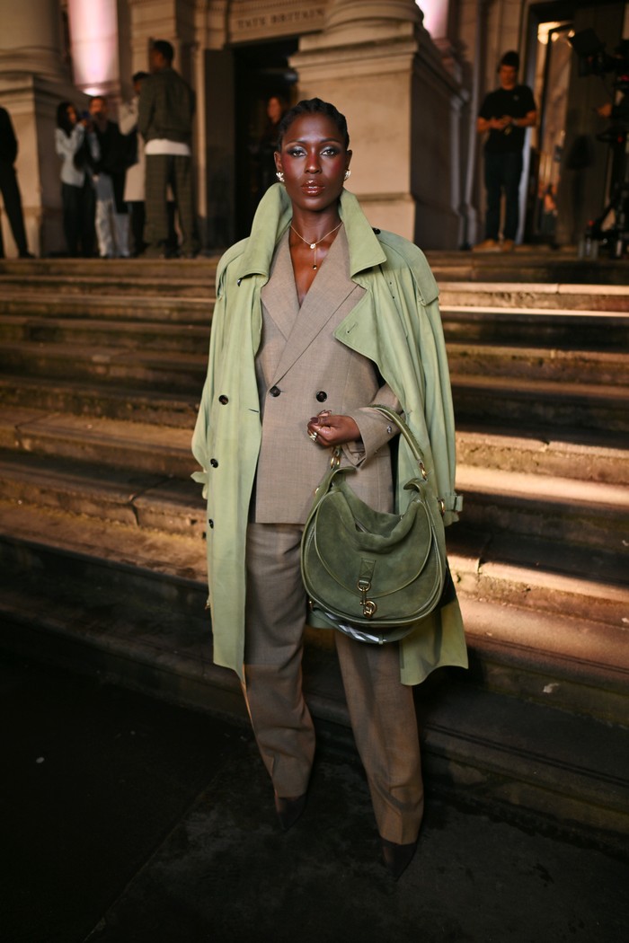 Jodie Turner-Smith tak pernah gagal memalingkan mata. Double jacket yang memainkan palet warna earthy membuat gayanya istimewa. Ya, double-breasted suit dalam rona coklat disandingkan single-breasted coat hijau yang senada dengan Burberry Messenger Bag di tangannya/ Foto: Courtesy of Burberry/Dave Benett/Dave Benett