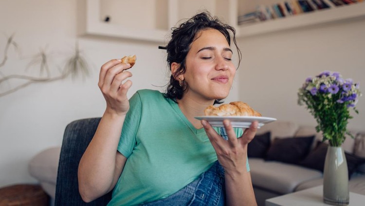 wanita makan Portrait of a beautiful girl enjoying her takeaway breakfast at home.
