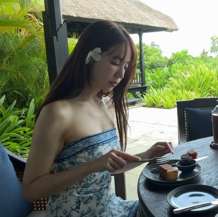 <p>Dalam video lain yang diunggahnya, Yoon Eun Hye juga menunjukkan momen saat <em>me time</em> dengan menikmati sarapan di dekat kolam renang dengan pemandangan bukit dan pepohonan hijau. "<em>A morning in Bali eating</em>," tulisnya. (Foto: Instagram @y1003_grace)</p>