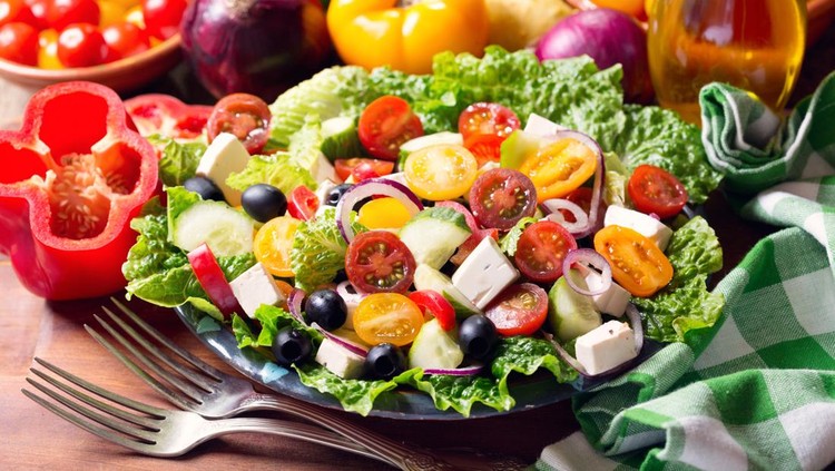 plate of greek salad on wooden table