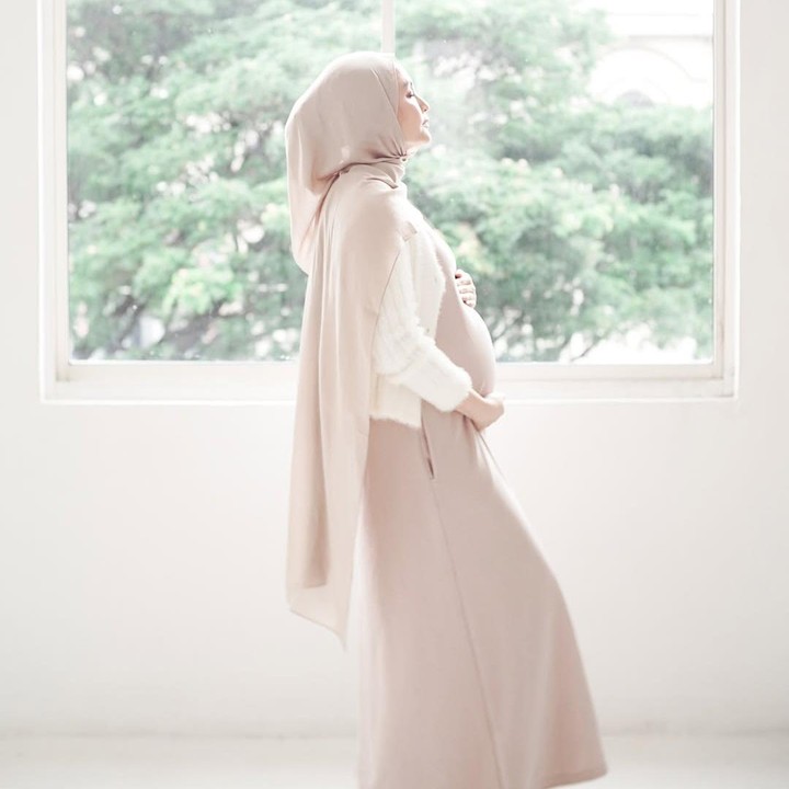 <p>Di <em>maternity shoot</em> ini, Indah tampil cantik mengenakan gaun casual berwarna <em>mocca</em> muda yang senada dengan warna jilbabnya. Bunda tiga anak ini padu padan gayanya dengan cardigan putih.(Foto: Instagram @indhningtys)</p>
