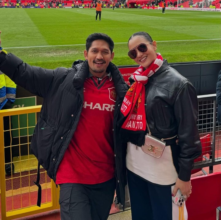 <p>Beberapa pasangan artis Indonesia memutuskan terbang ke luar negeri untuk menonton pertandingan sepak bola. Salah satunya adalah pasangan Ibnu Jamil dan Ririn Ekawati. Pada awal tahun ini, Ririn menemani suaminya menyaksikkan pertandingan sepak bola di stadion Old Trafford, Inggris. Ibnu Jamil memang diketahui supporter dari klub Manchester United (MU). (Foto: Instagram @ibnujamilo)</p>