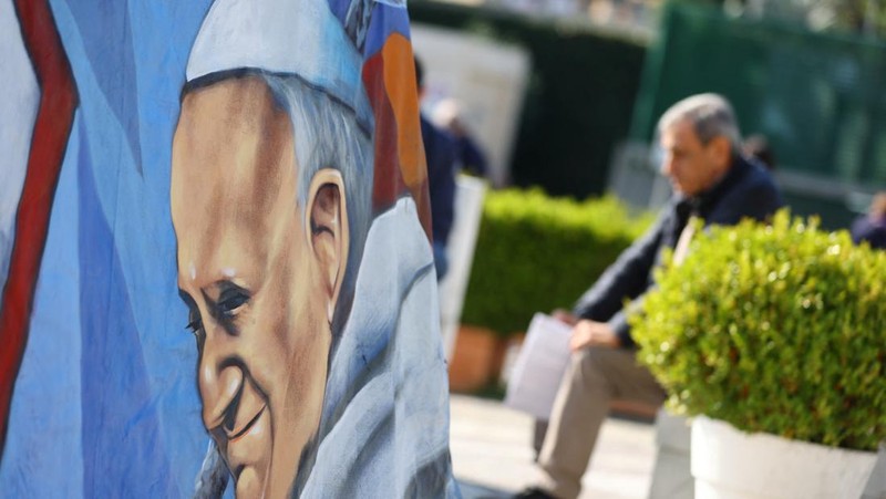 Orang-orang berdoa pada dekat patung mendiang Paus Yohanes Paulus II pada luar Rumah Sakit Gemelli tempat Paus Fransiskus dirawat, di dalam Roma, Italia, 5 Maret 2025. (REUTERS/Remo Casilli)