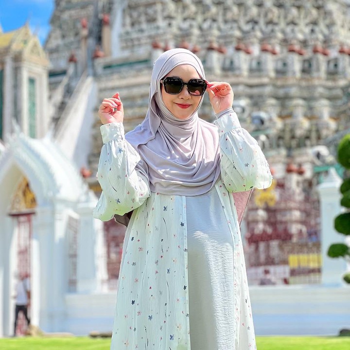 <p>Saat hamil anak ketiga, Bunda Seleb Annisa Rahma juga sering mengenakan gamis dengan berbagai model yang simpel. Misalnya saat berlibur ke Thailand, mantan personel girl group Cherrybelle ini mengenakan gamis putih dengan motif bunga kecil berwarna pastel. Anisa melengkapi gayanya dengan jilbab jersey warna ungu muda dan aksesoris kacamata hitam. (Foto: Instagram @anisarahma_12)</p>