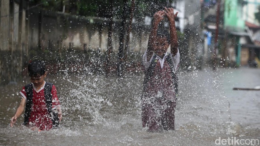 Anak-anak melewati banjir di Jl Kemuning III&comma; Pamulang&comma; Tangsel&comma; Senin &lpar;10&sol;3&sol;2025&rpar;&period; Jalanan banjir akibat hujan deras yang mengguyur&period;