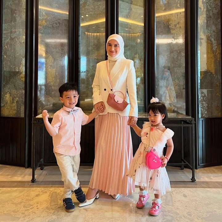 <p>Inspirasi <em>outfit</em> lainnya yang dapat Bunda ikuti adalah foto OOTD yang satu ini. Irish tampil elegan mengenakan jas putih yang dipadukan rok plisket berwarna <em>pink</em>. Selain itu, warna roknya ini juga senada dengan <em>sling bag</em> yang dipakainya, lho. (Foto: Instagram@_irishbella_)</p>