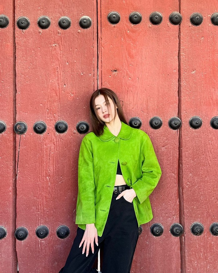 Jaket suede hijau dari Prada yang dikenakan Sana juga menarik perhatian. Dipadukan dengan crop top dan celana hitam sederhana, tampilannya terlihat modern dengan sentuhan retro yang menarik./ Foto: Instagram/m.by__sana