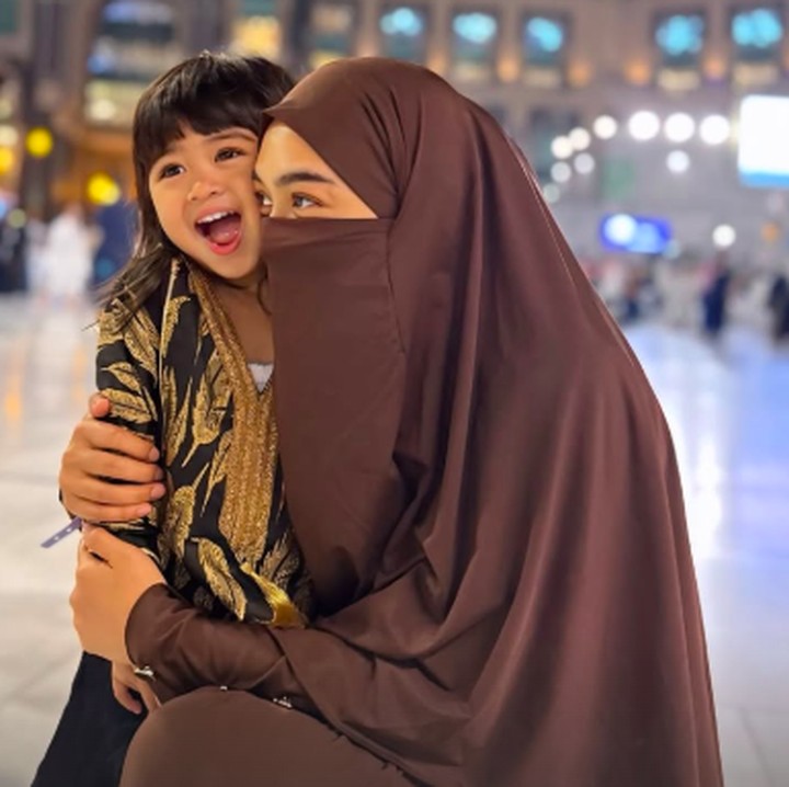 <p>OOTD Moana selama menjalankan ibadah umrah juga menarik perhatian netizen nih, Bunda. Pada sebuah potret, ia tampil menggemaskan dengan gamis warna hitam dan <em>gold</em>. (Foto: Instagram: @riaricis1795)</p>