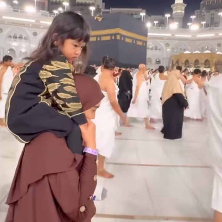 <p>Ketika melakukan tawaf mengelilingi Ka'Bah, Moana juga tidak mau lepas dari sang Bunda. Ricis pun menggendong sang putri sambil melanjutkan ibadahnya. (Foto: Instagram: @riaricis1795)</p>