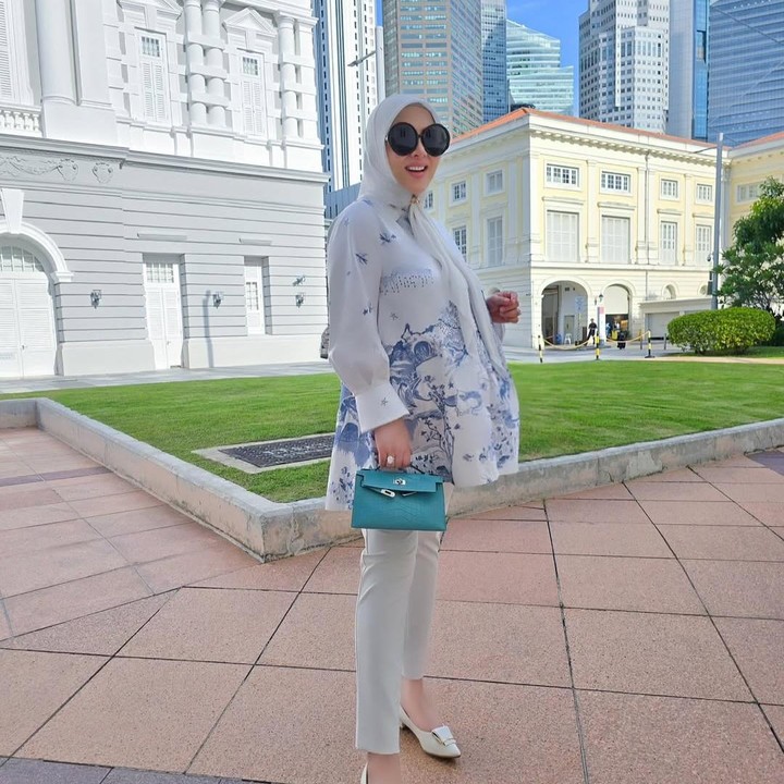<p>Syahrini kerap mengenakan pakaian yang stylish saat hamil anak pertamanya. Selama hamil, pelantun lagu <em>Seperti Itu?</em> tersebut sering membagikan OOTD yang bisa jadi inspirasi bukber Bunda. Syahrini mengenakan blouse putih dengan corak biru, yang dipadu padan dengan celana, jilbab, dan sepatu putih. Syahrini melengkapi penampilannya dengan tas kecil berwarna biru muda. (Foto: Instagram @princessyahrini)</p>