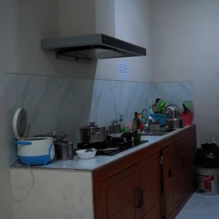 <p>Kos-kosan Nunung dan suami ini memiliki dapur bersama yang digunakan penghuni lain juga. Meski begitu, tempat ini sering dipakai Nunung untuk memasak makanan kesukaannya. (Foto: YouTube Melaney Ricardo)</p>