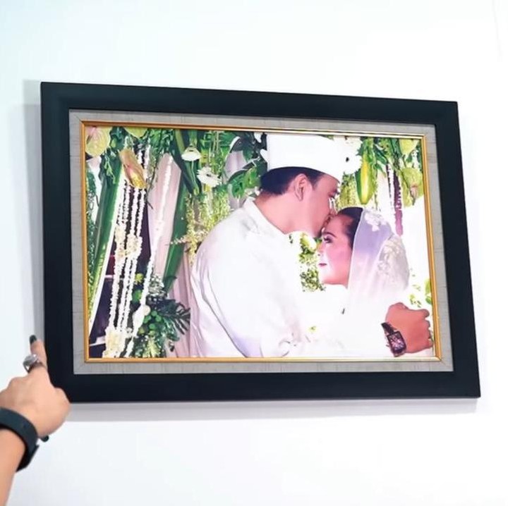 <p>Di kamar kos-kosan yang cukup dengan satu tempat tidur ini, Nunung dan suami menghiasi dinding mereka dengan foto pernikahan 13 tahun yang lalu. Itu menjadi satu-satunya foto mereka yang dipanjang di tempat tinggalnya saat ini. (Foto: YouTube Melaney Ricardo)</p>