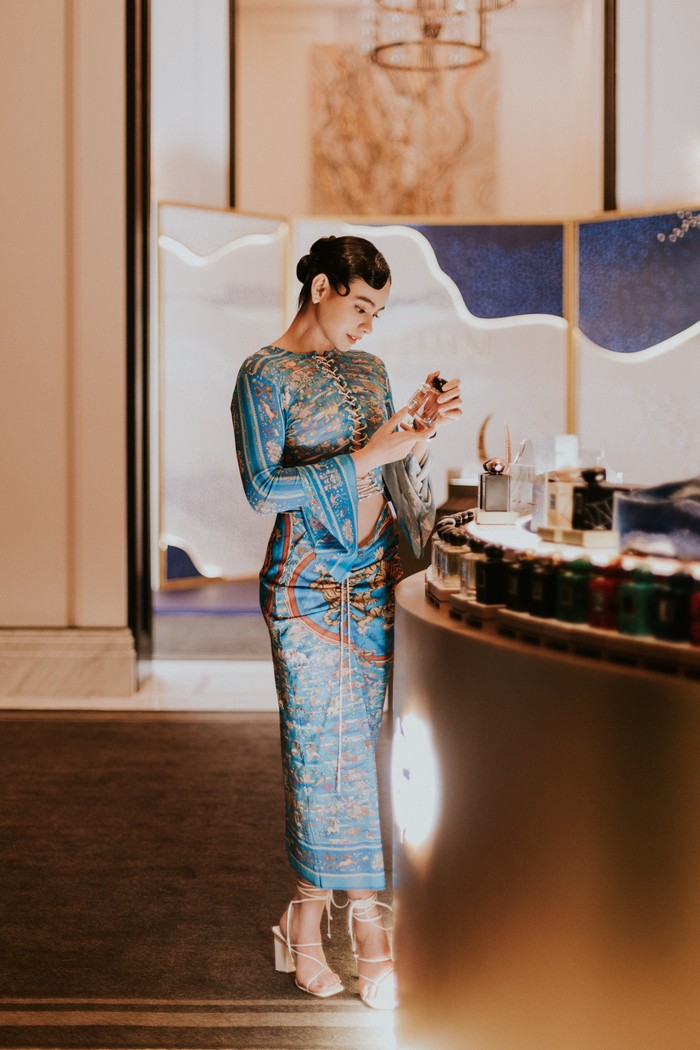 Berbalut busana hasil tangan Dibba, penampilan Sahila Isyam istimewa. Motif etnik busana dalam warna biru berkesan modern dan seksi dengan aksen lace up dan cut out di sisi depan. Untuk mengimbangi maxi dress yang atraktif tersebut, strappy heels dalam rona netral dikenakannya/ Foto: Dok. Armani Beauty/VINCENTIUS