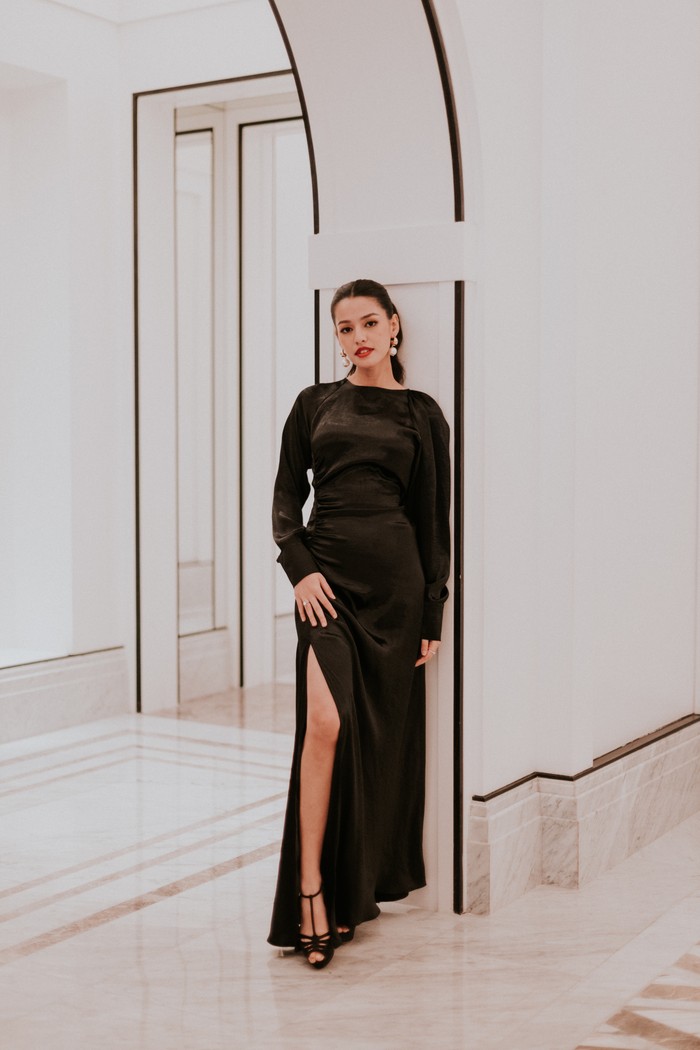 Gaya head-to-toe black selalu bisa diandalkan untuk membuat gaya elegan, cocok dikenakan ke acara malam. Gaya itu pula yang menjadi pilihan Suzana Sameh. Elegan berbalut maxi dress lengan panjang dengan thigh-high slit yang beri sentuhan sensual. T-strap heels senada serta anting mutiara menegaskan aura berkelas/ Foto: Dok. Armani Beauty/VINCENTIUS