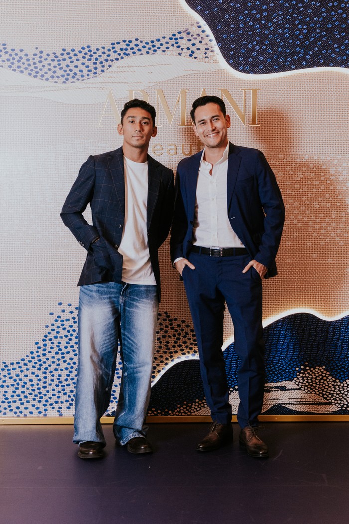 Serupa tapi tak sama, Daffa Wardhana dan Arifin Putra punya pesona berbeda. Daffa dalam tampilan semi-formalnya menggabungkan jeans dan kaus putih dengan blazer motif tattersall check nan preppy, sedangkan Arifin berkesan lebih formal dan klasik dengan perpaduan setelan jas navy dan kemeja putih./ Foto: Dok. Armani Beauty/VINCENTIUS
