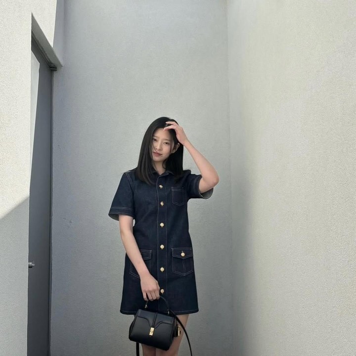 <p>Denim dress yang dikenakan Min Ju memberi kesan simpel sekaligus kasual, Bunda. Warna tas dan juga bajunya yang netral membuatnya terlihat lebih stylish. (Foto: Instagram: @minn.__.ju)</p>