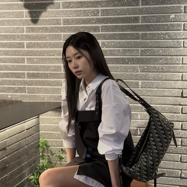<p>Kim Min Ju mengenakan kemeja putih dibalut outer jumpsuit dress membuatnya terlihat kasual tapi stylish dan juga bold. Apalagi ditambah dengan shoulder bag-nya. (Foto: Instagram: @minn.__.ju)</p>