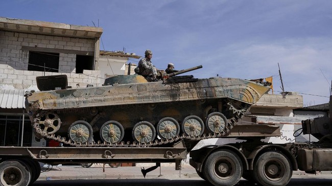 Syrian troops sit atop a military vehicle as they head towards the Syrian-Lebanese border following clashes with Lebanese soldiers and armed groups, in Qusayr, Syria, March 17, 2025. REUTERS/Karam al-Masri     TPX IMAGES OF THE DAY