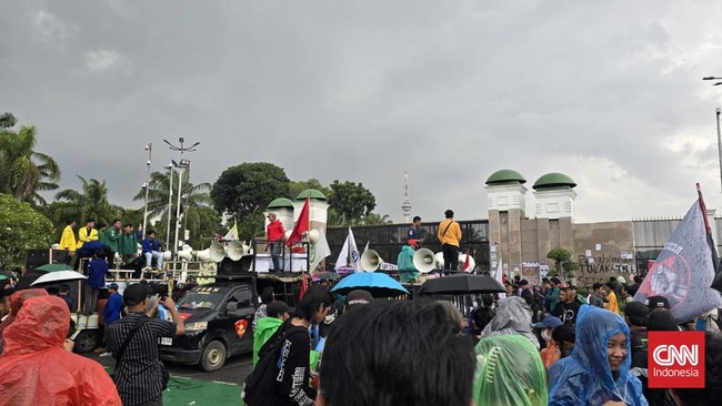 Massa aksi tolak UU TNI masih bertahan di depan gedung DPR, Jakarta, Kamis (20/3) sore di tengah guyuran hujan deras.