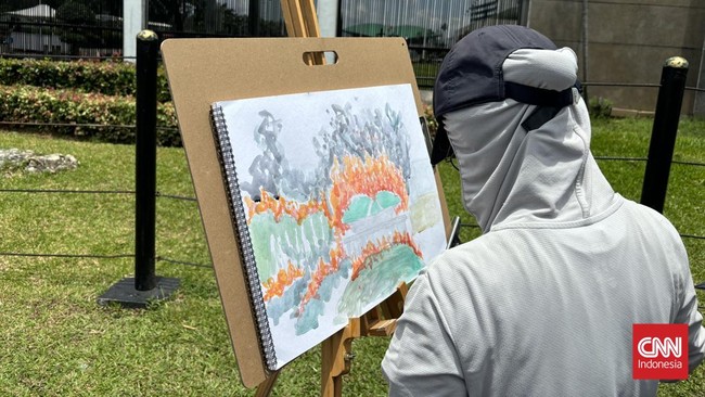 Seorang seniman menggelar aksi live painting di depan Kompleks DPR/MPR RI di tengah gelombang penolakan terhadap RUU TNI.
