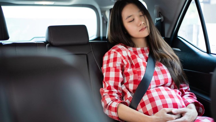 Pregnant asian women she is sleeping in the car.