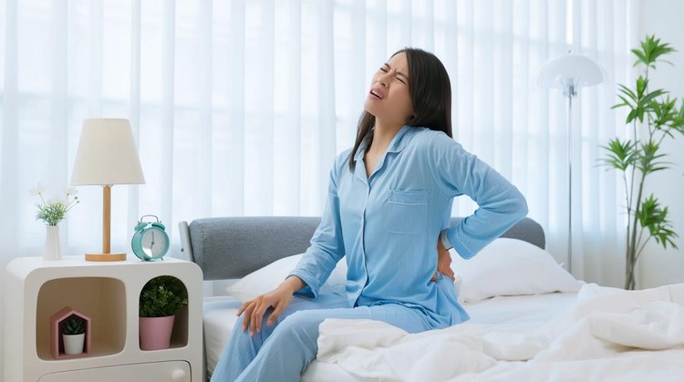 Asian woman wake up in the morning with back pain - she did not sleep well