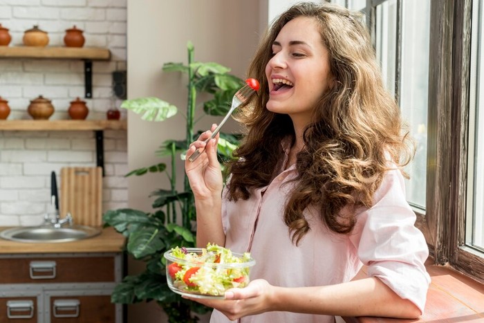 Ilustrasi Seorang wanita makan salad/Foto: freepik.com/freepik