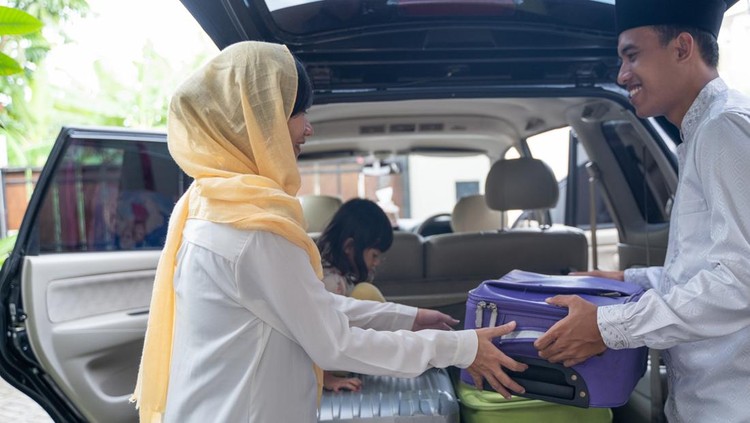 portrait of muslim asian couple put suitcase in the car trunk