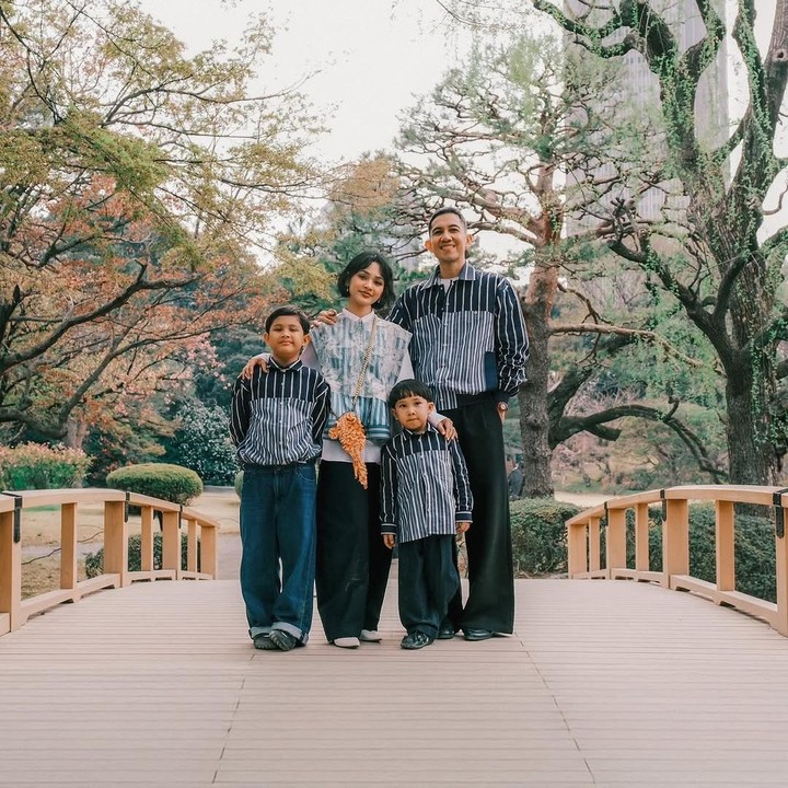 <p>Dalam foto yang dibagikannya, Andien dan keluarganya terlihat kompak mengenakan baju dengan desain serupa. Andien tampak mengenakan baju garis abu-abu putih yang dipadukan dengan celana hitam. Sementara itu, sang suami Irfan Wahyudi memakai baju bergaris biru-putih, senada dengan pakaian yang dikenakan kedua putranya, Kawa dan Tabi. (Foto: Instagram @andienaisyah)</p>