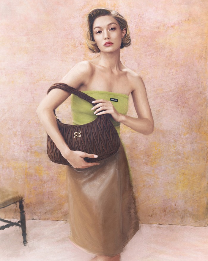 Gigi Hadid, berdandan retro dengan tatanan rambut bob bergelombang khas Old-Hollywood, berpose sambil memamerkan rancangan Miu Miu matelassé suede terbaru dalam wujud tas Arcadie dan Wander/ Foto: Dok. Miu Miu/Steven Meisel