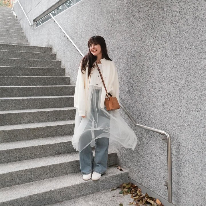 <p>Berbeda dengan Andien, aktris Audi Marissa memadukan celana <em>jeans high waist</em> dengan baju terusan putih di mana bagian bawah baju dari pinggang terbuat dari kain tipis berbahan tulle putih. Untuk melengkapi penampilannya, Bunda satu anak ini mengenakan jaket berwarna putih dan tas cokelat. (Foto: Instagram @audimarissa)</p>