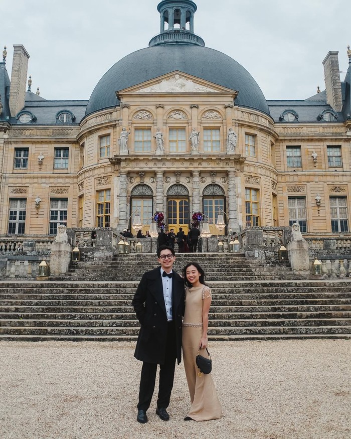 Gayanya tentu berbeda saat kondangan di Paris. Ditemani Brandon Salim, keduanya sama-sama pakai outfit formal dalam warna netral. Warna khaki pada flare jumpsuit yang membalut Dhika lebih glamor dengan aksen mutiara dan kristal di pinggang dan lengan. Seolah sengaja dikoordinasikan dengan outfit Brandon, tas Dior saddle dan pointy shoes hitam digunakan/ Foto: Instagram.com/dhikahimawann