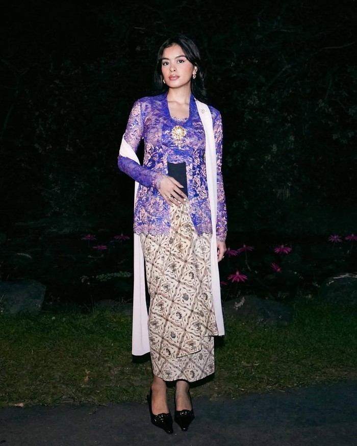 Eva Celia mengenakan kebaya kembang klasik dalam warna ungu. Kebaya kutubaru itu dipadu stagen hitam serta kain batik sidomulyo. Selendang, bros, dan anting emas menyempurnakan gaya tradisionalnya/Foto: Instagram.com/evacelia