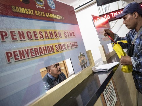 Warga menyerahkan dokumen di loket pengesahan STNK saat pembayaran pajak kendaraan bermotor di Kantor Samsat 1 Kota Semarang, Pedurungan, Semarang, Jawa Tengah, Selasa (22/4/2025). Badan Pengelola Pendapatan Daerah (Bapenda) Provinsi Jawa Tengah menc
