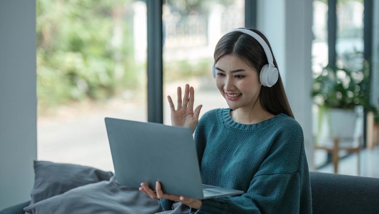 ilustrasi video call Work at home young asian woman working on laptop computer while sitting and hold coffee cup at home Morning lifestyle concept