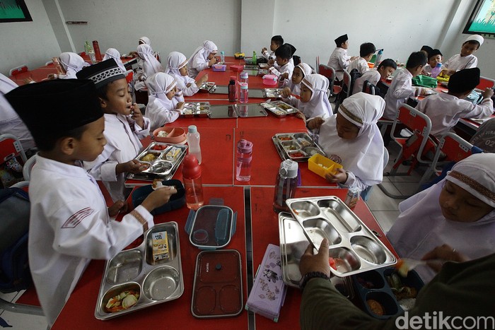 Murid SD menerima dan menyantap menu makan bergizi gratis di SDN Jurang Mangu Timur 02, Tangerang Selatan, Banten, Selasa (25/4/2025).