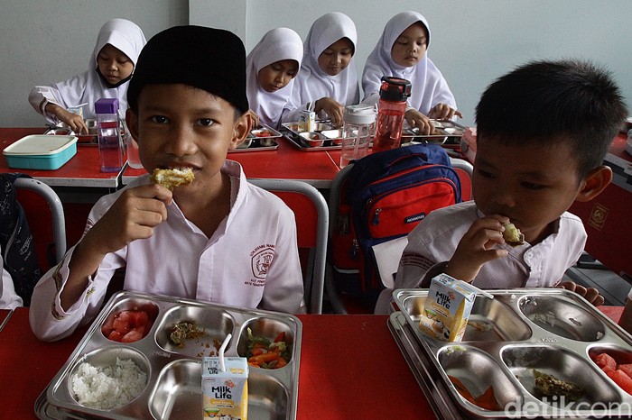 Murid SD menerima dan menyantap menu makan bergizi gratis di SDN Jurang Mangu Timur 02, Tangerang Selatan, Banten, Selasa (25/4/2025).