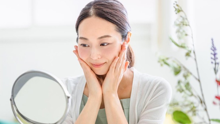 Ilustrasi wanita wajah glowing woman doing skin care looking in the mirror (beauty image)