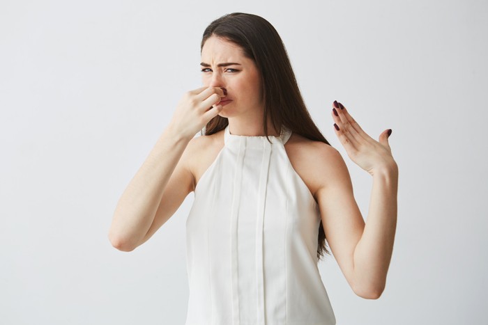 Ilustrasi perempuan menutup hidung karena mencium bau mulut yang tak sedap/ Foto: Freepik/ Cookie_Studio