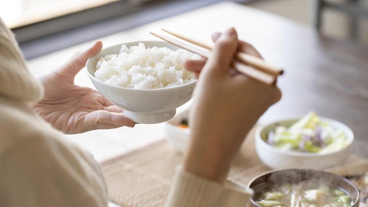 Ilustrasi orang Jepang makan nasi Hand of young woman eating breakfast