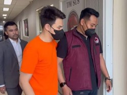 Jonathan Frizzy Berbaju Oranye dan Masker Hitam di Kantor Polisi