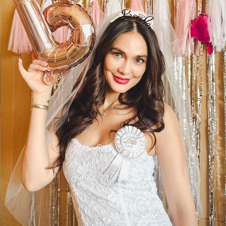 <p>Di foto lain, Luna terlihat anggun mengenakan gaun pengantin putih lengkap dengan <em>veil</em> dan bando bertuliskan 'Bride'. Bintang film <em>Suzzanna: Bernapas dalam Kubur</em> ini tak lupa memamerkan raut wajah bahagianya yang <em>full</em> senyum. (Foto: Instagram @lunamaya)</p>