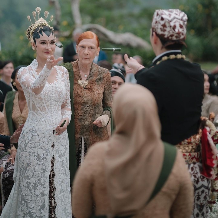 <p>Saat prosesi akad nikah, sang Bunda pun mendampingi Luna bertemu Maxime dengan mengenakan kebaya cokelat yang dilengkapi selendang berwarna hijau. Tangannya menggandeng sang putri yang kini telah resmi menjadi seorang istri. (Foto: Instagram@lunamaya)</p>