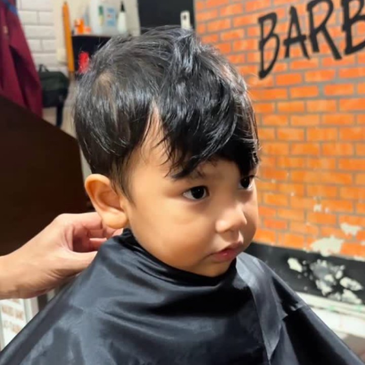 <p>Dalam video, terlihat Naka sudah mengenakan <em>cape</em> atau apron hitam di tubuhnya. Tidak hanya itu, tampak pula rambut Naka yang mulai panjang dan menutupi mata. (Foto: Instagram: @indahpermatas)</p>