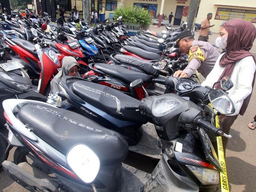 Polisi mendampingi warga mencari sepeda motornya saat mengecek barang bukti sepeda motor hasil rampasan di Polres Bogor, Kabupaten Bogor, Jawa Barat, Jumat (9/5/2025). Polres Bogor bersama Polresta Bogor Kota menggelar konferensi pers kasus perampasa