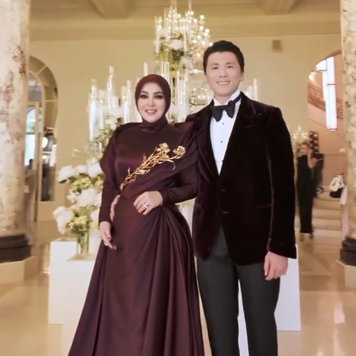 <p>Syahrini tak datang sendiri, Bunda. Pelantun lagu <em>Sesuatu</em> ini terlihat didampingi oleh suaminya, Reino Barack. Sang suami tampak mengenakan setelan jas beludru berwarna merah <em>maroon</em> gelap yang dipadukan dengan celana hitam. (Foto: Instagram @princessyahrini)</p>