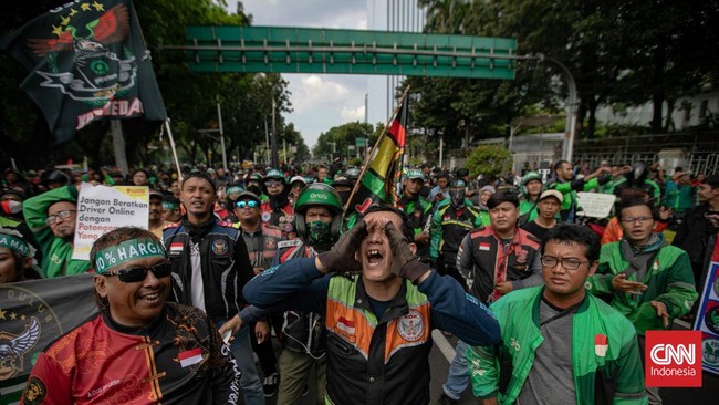 Massa Ojol Bakar Ban, Polisi Ancam Tembak Water Cannon Massa ojek online demonstrasi di Jakarta, membakar ban sebagai protes. Mereka menuntut kenaikan tarif dan regulasi transportasi online.