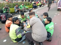 Aksi Humanis Polisi Bagi-bagi Minuman ke Massa Demo Ojol di Patung Kuda