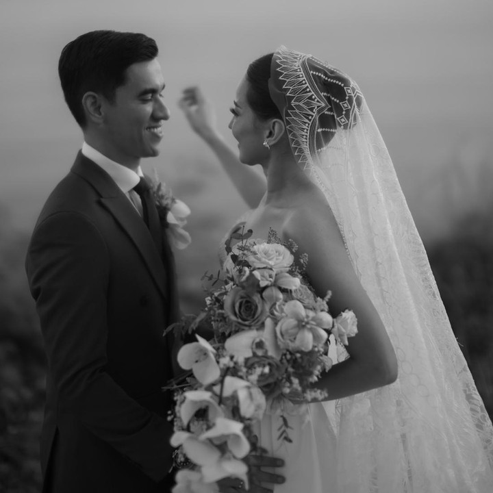 <p>Melalui unggahan di Instagram, Enzy mem-posting foto pernikahannya untuk merayakan wedding anniversary kedua. Di foto hitam putih ini, Enzy terlihat mengenakan gaun pernikahannya yang anggun, sementara sang suami memakai setelan tuksedo. (Foto: Instagram @enzystoria)</p>